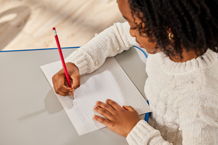 Girl writing in classroom